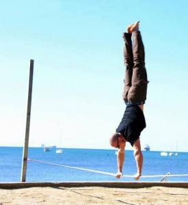 Man performing a handstand on a slackline